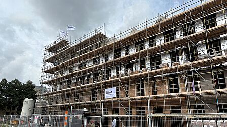 Gebouw in steigers met vlag op het hoogste punt