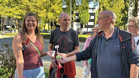 3 bewoners laten zien wat ze aan afval hebben opgeraapt, waaronder een tennisbal 