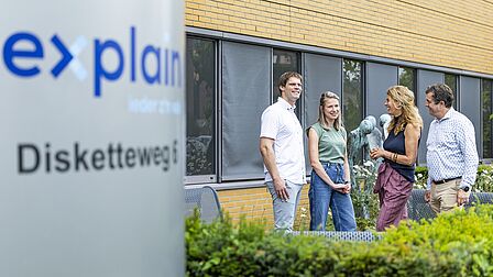 Rob staat naast 3 collega's voor het bedrijfspand