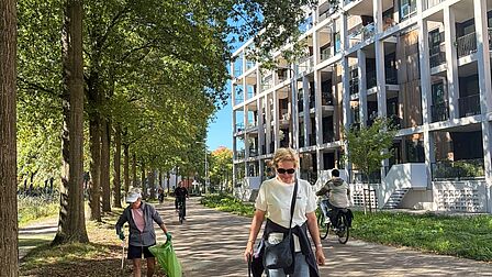 2 mensen die lopen met een afvalgrijper