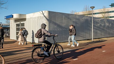 Een fietser rijdt voor de fietsenstalling langs