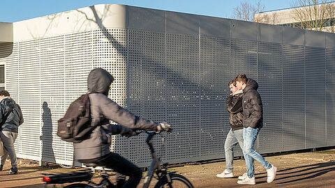 Een fietser rijdt voor de fietsenstalling langs