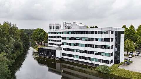 Impressie hoe het gebouw eruit komt te zien; 5 verdiepingen hoog naast het water